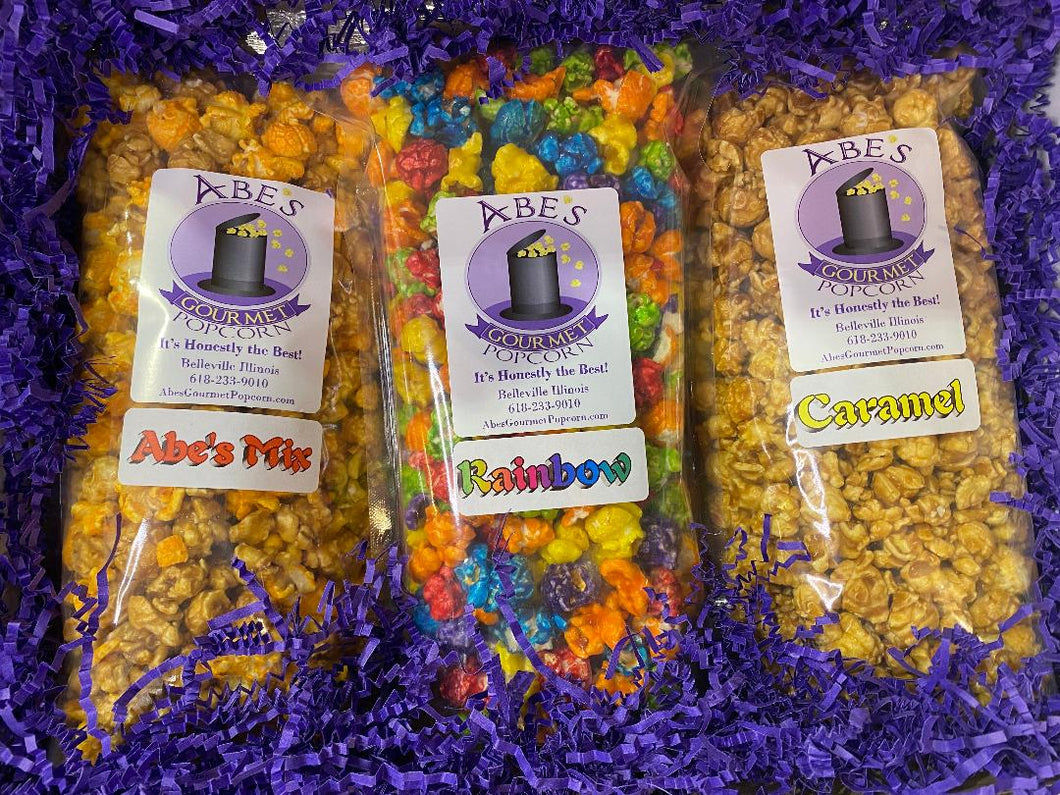 Inside of the Mix it Up  Gourmet popcorn gift box showing the 3 bags of popcorn in shredded crinkle paper